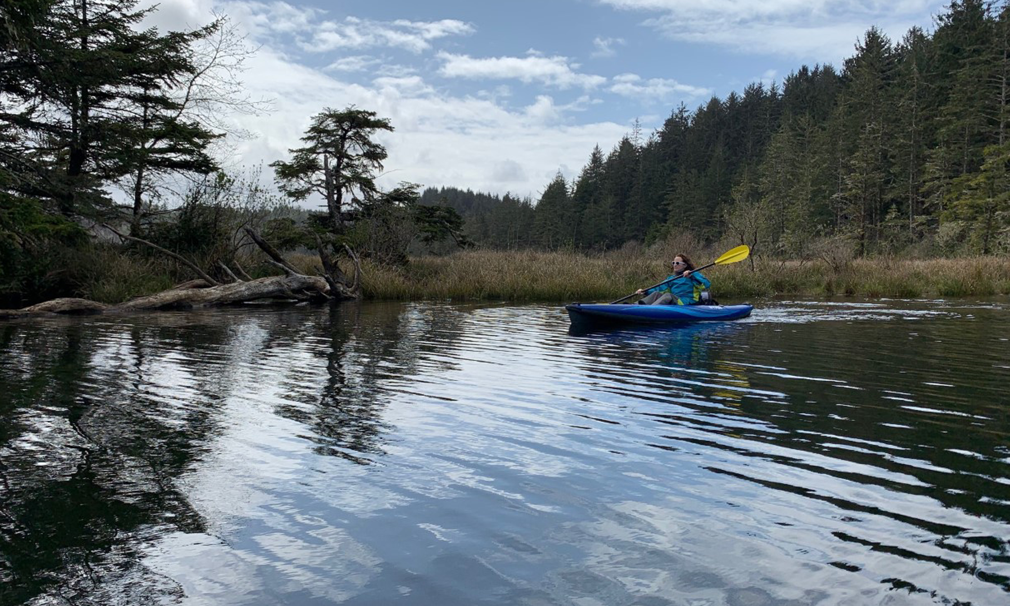 Person enjoying an inflatable kayak rental from Oregon River Rentals in Portland, Oregon, with scenic water views.
