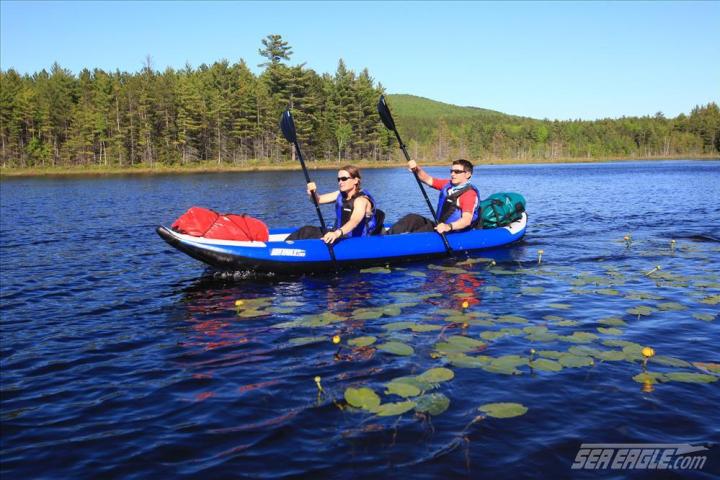 a group of people in a small boat in a body of water